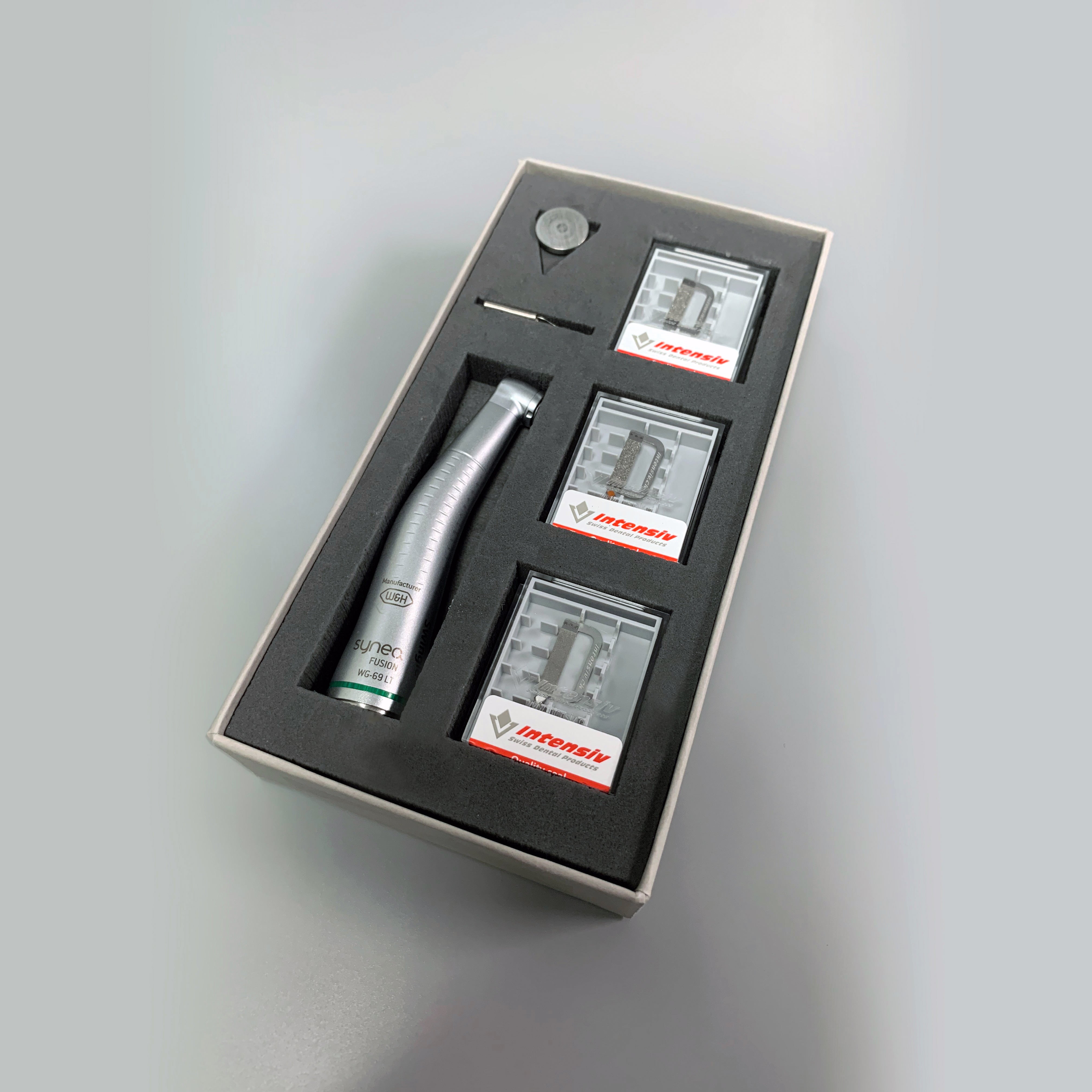Winkelstück Intensiv Swingle mit Licht W&H Synea, Ausstosser, Spraykanal, Reinigungsnadel, 6x Ortho-Strips Aufsätze, Mechanische approximale Schmelzreduktion ASR mit oszillierenden Strips, Effizientes und kalibriertes Stripping; Hub 0,9 mm; 20.000 oszillierende Bewewegung bei 40.000 U/Min; Freidrehend oder 12 fixierte Positionen innerhalb 360°; Inkl. 1x Opener Ortho-Strip doppelseitig, 1x Coarse Ortho-Strips doppelseitig, 4x ortho-Strips doppelseitig, mit Licht